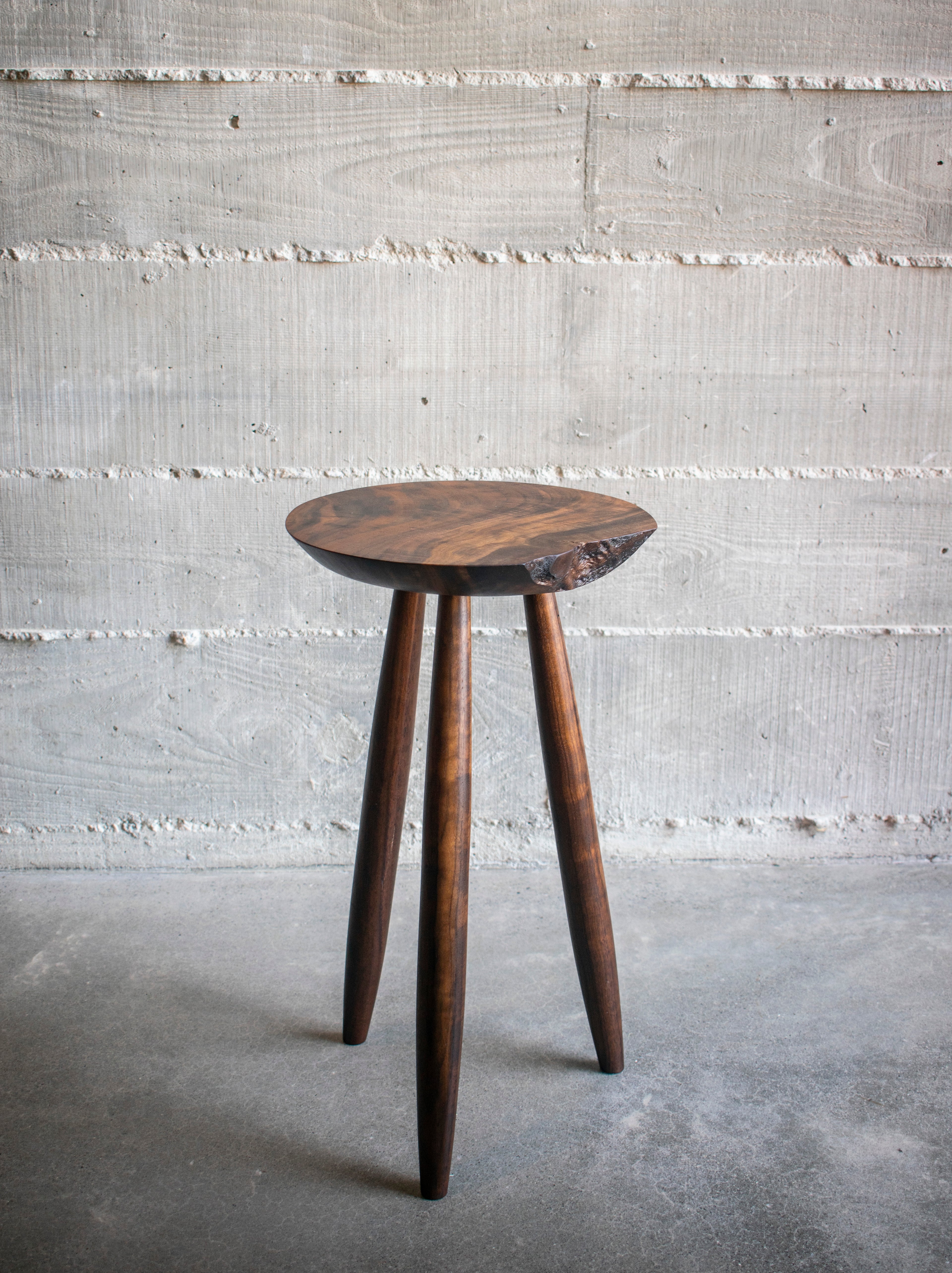 Live-edge walnut side table, full length showing tapered tripod legs